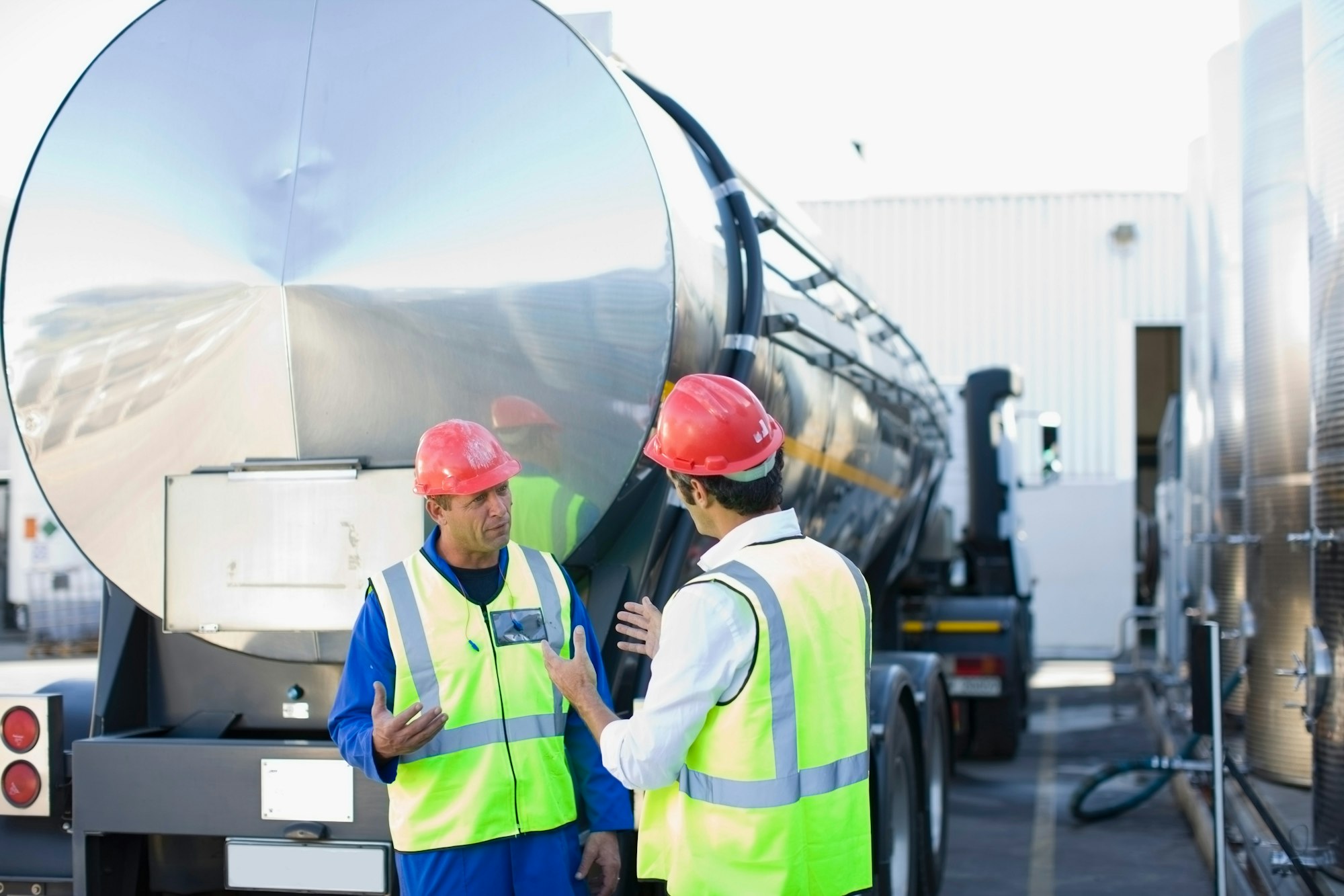 Workers talking by tanker truck